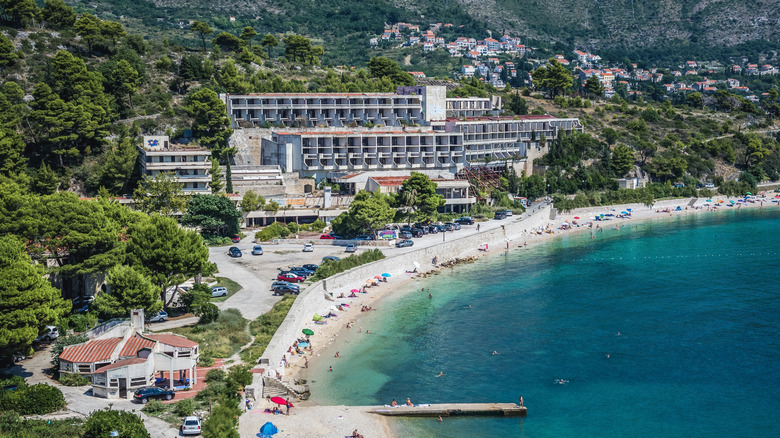 A large abandoned hotel complex among bright blue water and beaches