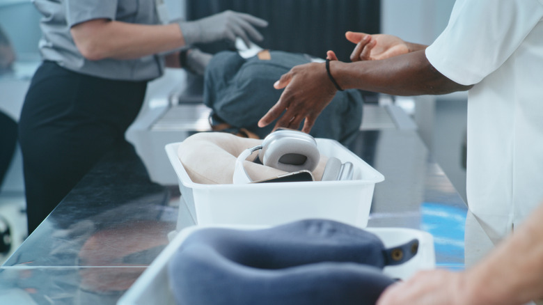 close-up of airport security worker with traveler's items in a bin