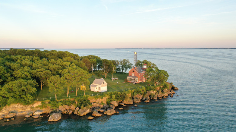Aerieal view of a rocky shore with a two lakefront houses surrounded by trees on Kellys Island