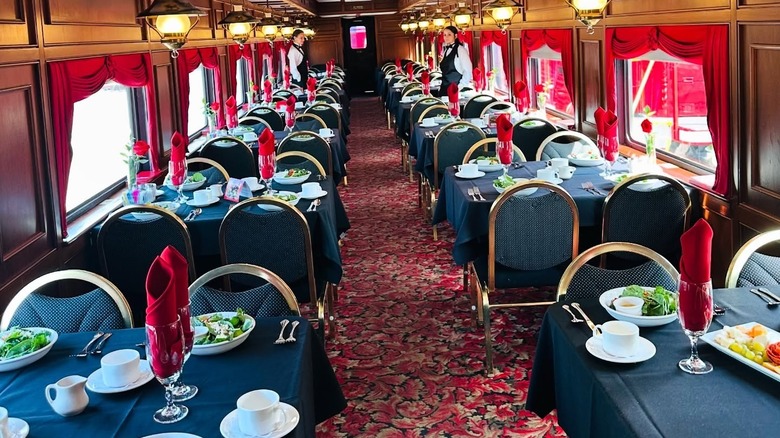 A young woman in a suit jacket in a rail car