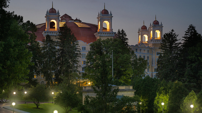 The towers of West Baden Springs Hotel lit up at night, surrounded by pine trees