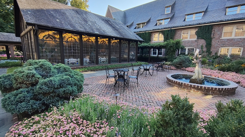 The low-slung brick building of The American Club with an elegant courtyard and fountain