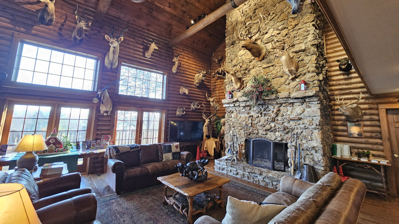 Cozy and luxurious cabin-style lounge with rock fireplace and leather furniture at Indian Point