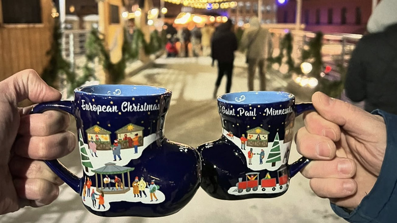 two blue Christmas mugs being held up to camera
