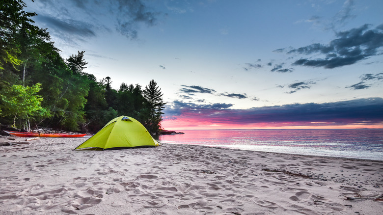 A tent on a sandy beach at sunrise on the Apostle Islands.