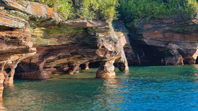 Sea caves on Lake Superior surrounded by trees.