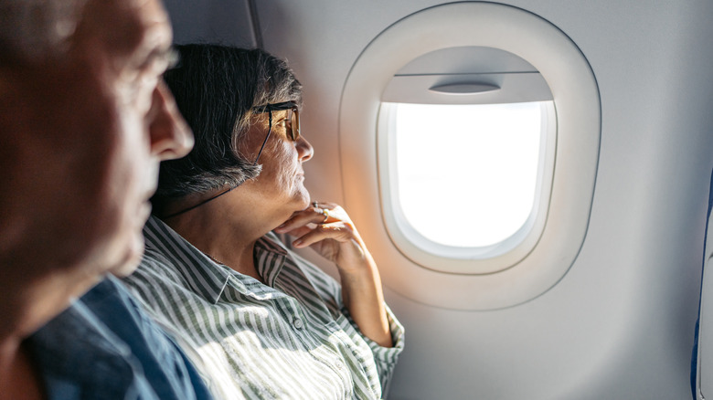 A passenger looking out the window of an airplane