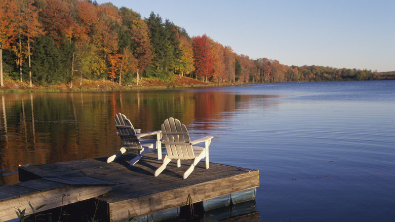 Adriondack chairs on a dock overlooking an autumnal lake in the Poconos