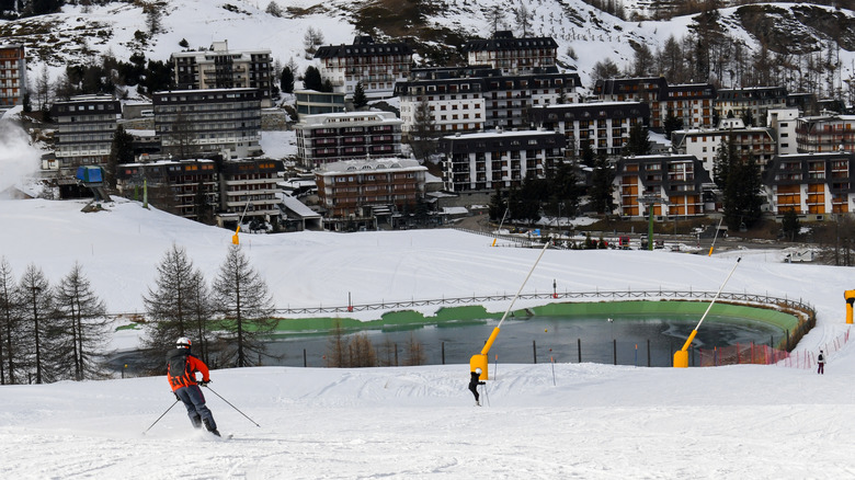 Skier skiing with Sestriere Ski Resort at the base of mountain