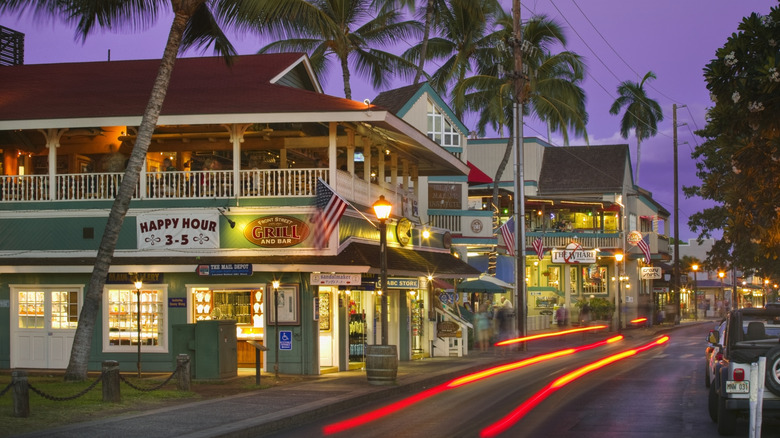 Lahaina street at sunset with passing car lights.