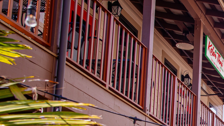 Stores in Old Koloa Town with plants and balconies.