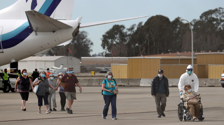 Passengers walking across the tarmac from a plane