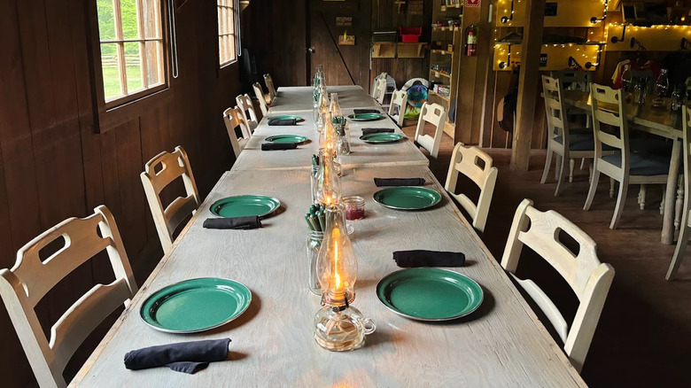 A table is set inside of Charit Creek Lodge with simple green plates and napkins
