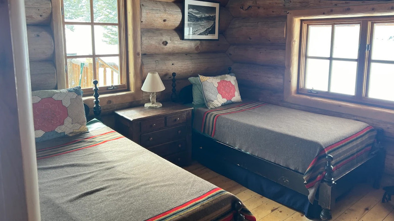 A bedroom with two single beds and log walls Shrine Mountain Inn, Colorado