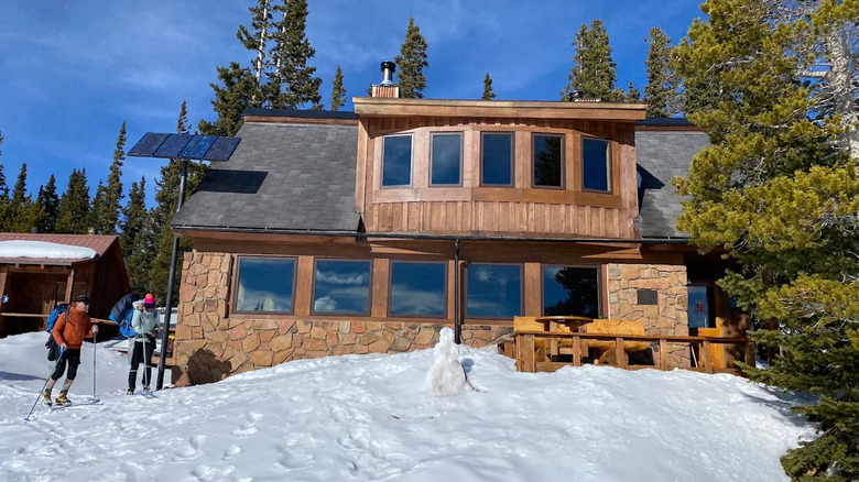 Two skiers approach Uncle Bud's Hut in Colorado on a sunny day