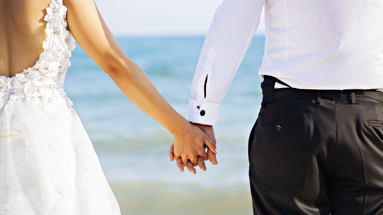 Couple holding hands on beach 