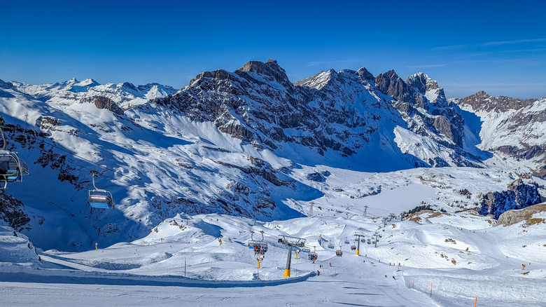 Ski resort nestled between snowy peaks against a blue sky