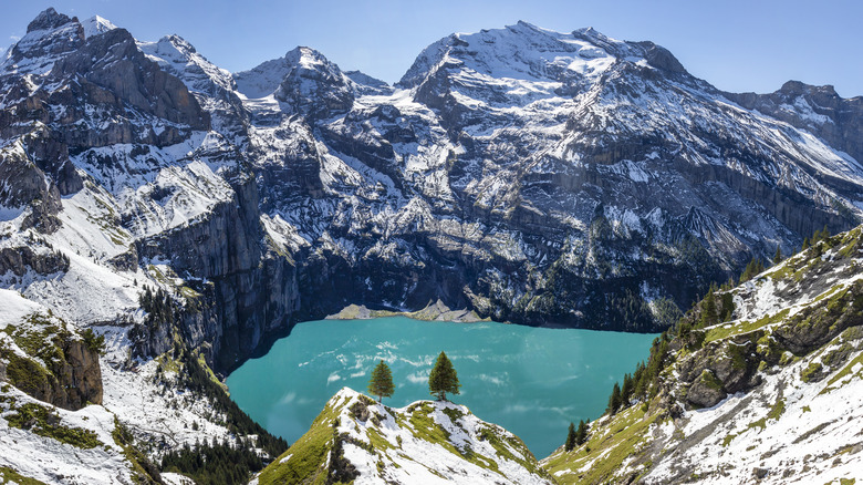 Turquoise lake interlocked between pointy snowy peaks