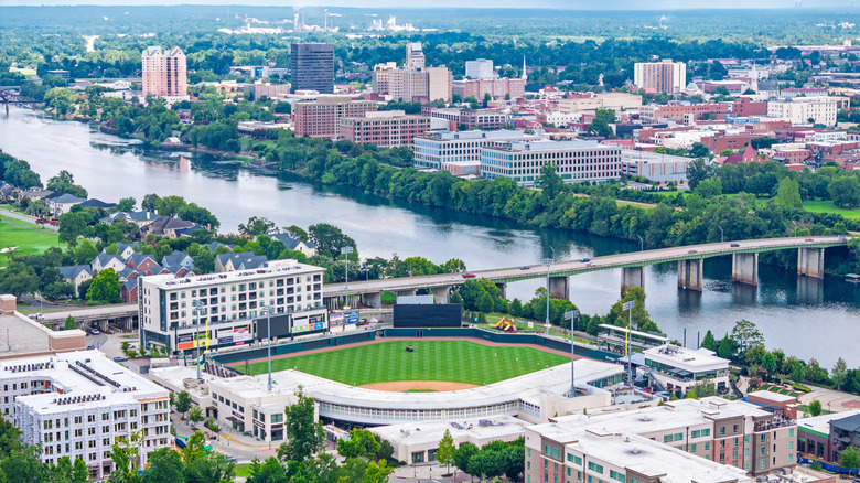 A photograph of North Augusta featuring a lush baseball field, the 13th Street bridge, and the Savannah River
