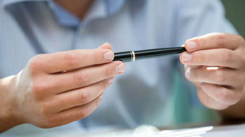 A man holding a black pen.