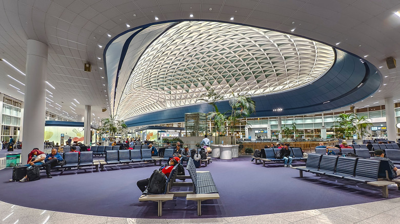Passengers relaxing on benches under Incheon Airport's domed ceiling