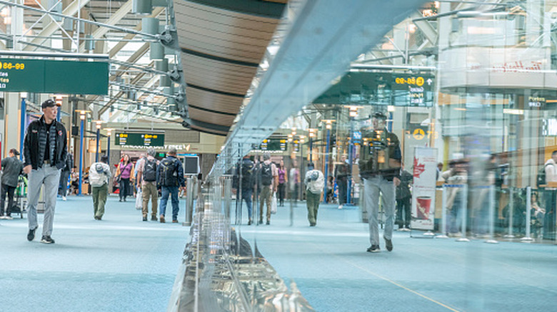 Passengers walk to their gate at Vancouver International Airport in Vancouver, BC, Canada.