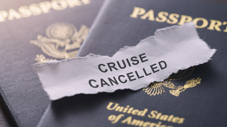 Slip of paper reading "CRUISE CANCELLED" laying on top of two U.S. passports, close-up