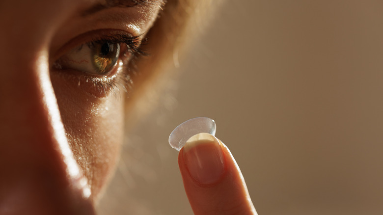 Person putting in contact lens