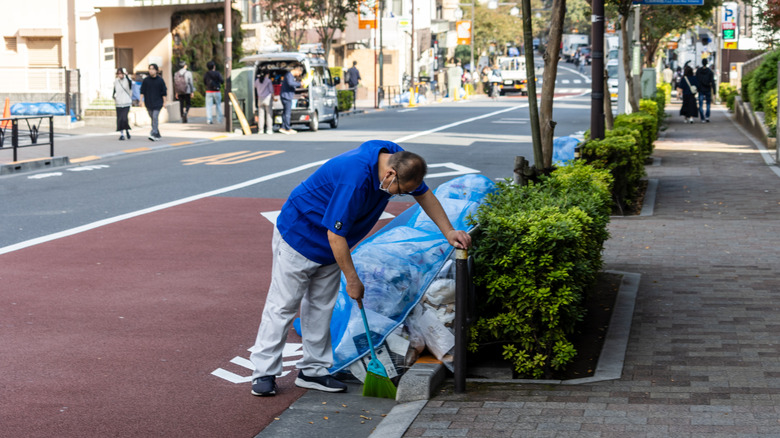 Worker picks up trash on street