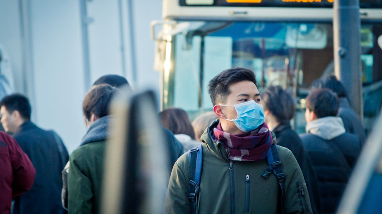 Masked man stands in crowd