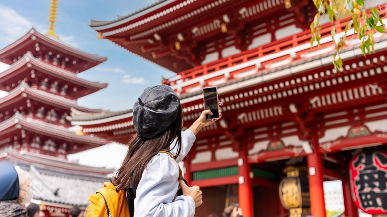 Woman photographs Japanese temple