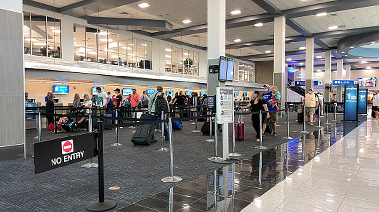 People waiting to get tickets and check baggage at the Allegiant counter at Sanford Airport in Florida