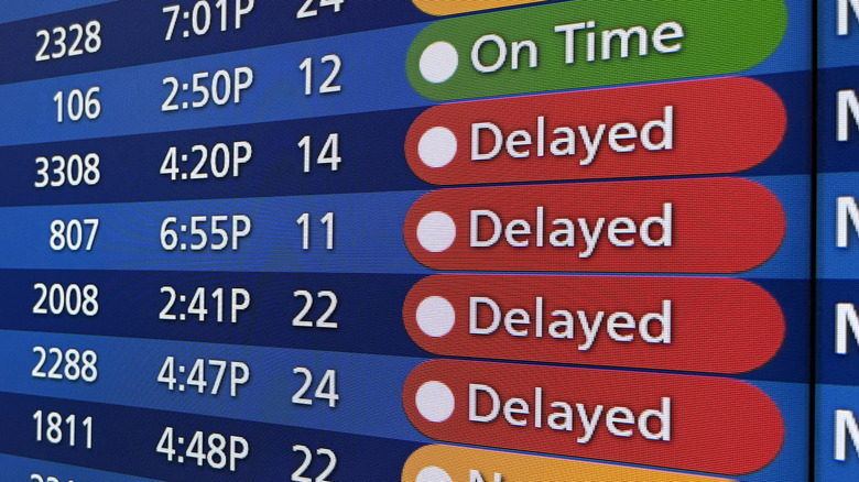 Close-up of a video board showing flight delays and arrivals