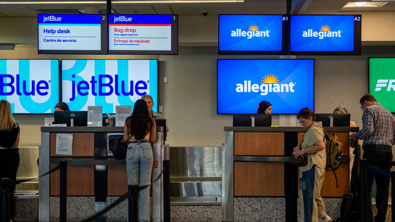 Travelers wait in line at an Allegiant Air ticketing counter at the Austin-Bergstrom International Airport on May 14, 2026 in Austin, Texas.