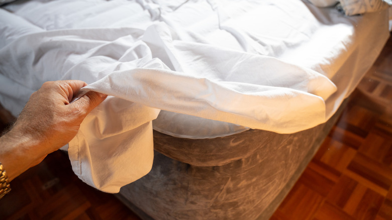 Person stripping a bed