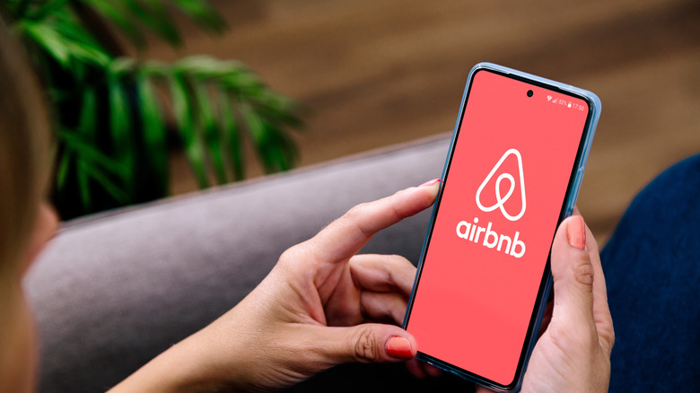 A person looking at the Airbnb app on their phone