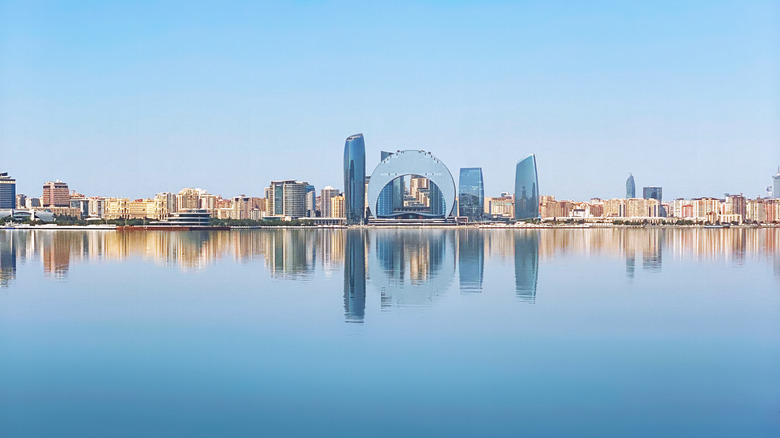 Architectural landmarks of Baku business downtown at sunset as seen from across the sea