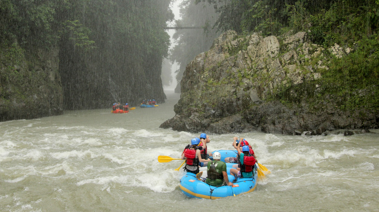 A group of people rafting on the Río Pacuare in the pouring rain.