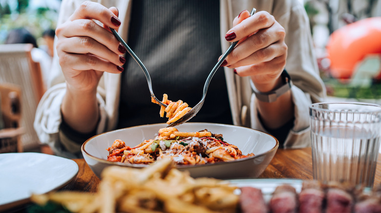 Woman eating spaghetti at a restaurant