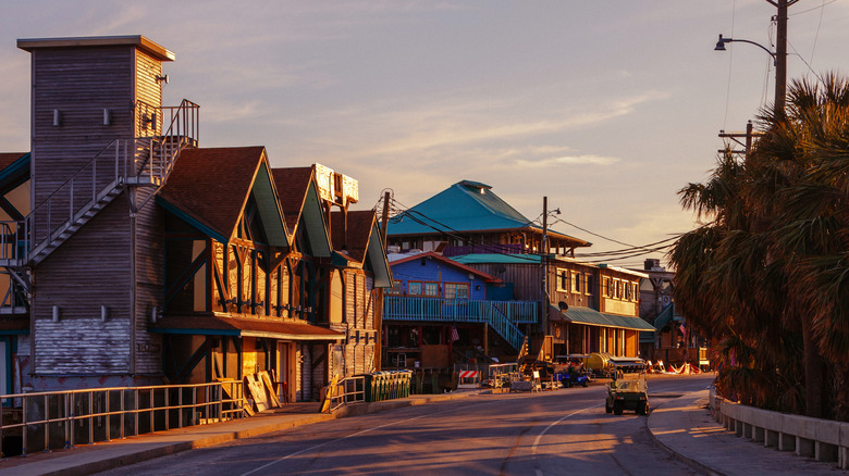 A historic street in Cedar Key at the golden hour, with hurricane-damaged buildings