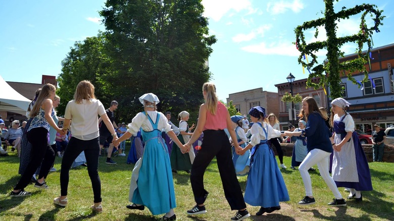 People in a circle in Hancock, Michigan, for the Juhannus Festival, dancing by the Midsummer Pole