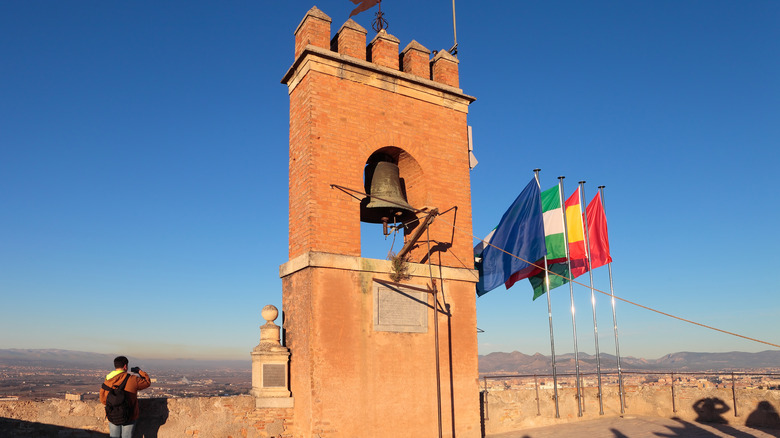 Tourist at monument with flags