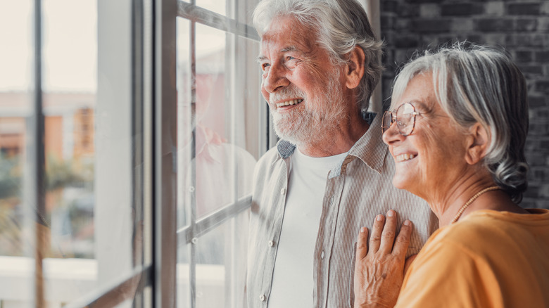 Retired couple smiling looking out window