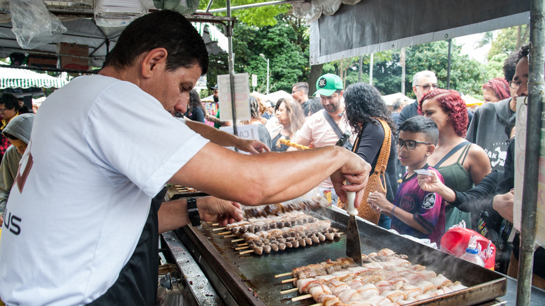 A man preparing street food at a fair in Belo Horizonte, Brazil