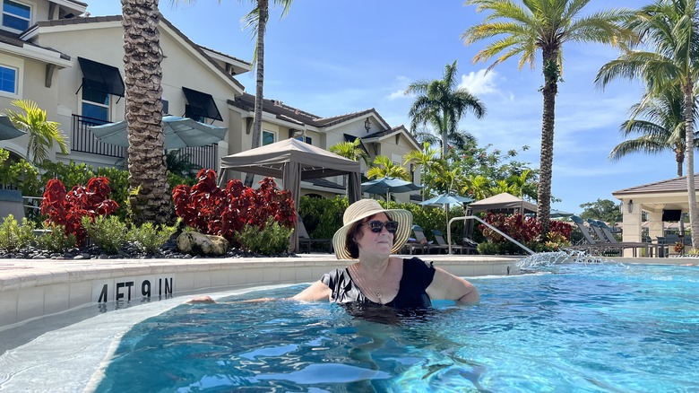 A senior woman in a pool at a resort