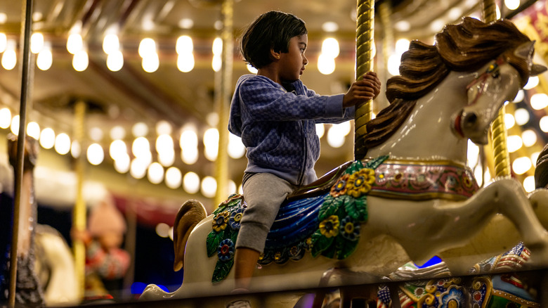 A child rides the merry-go-round during the Austin Trail of Lights festival at Zilker Park.