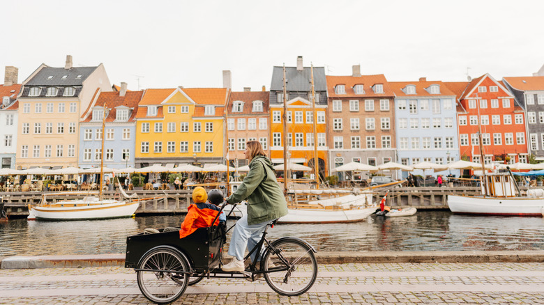 A cyclist riding along the side of the water in Copenhagen