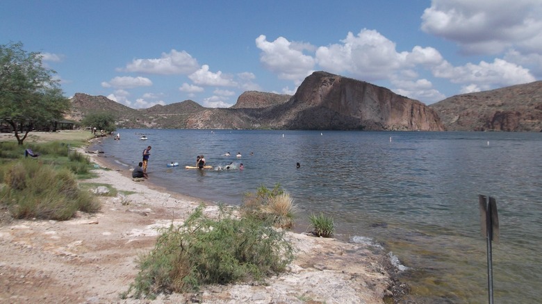 People swim and paddleboard in Apache Lake, Arizona