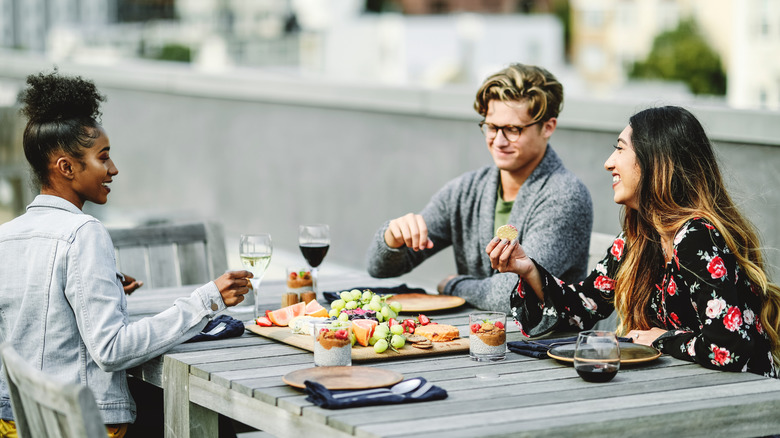 Friends eating vegetarian food on a having a rooftop in San Francisco