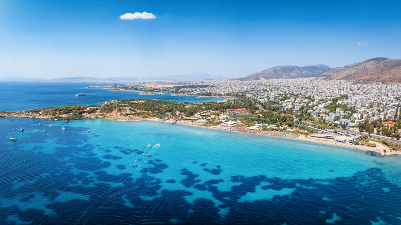 Aerial view of the turqouise waters off Voula Beach, Athens, backed by residential buildings
